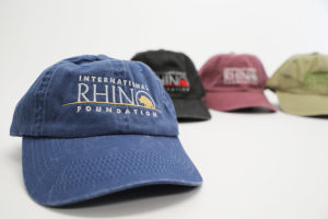 Set of multi-colored baseball hats for the International Rhino Foundation. The hats are branded with their logo. The logo is stitched with very vibrant colors in accordance with the different cool-toned hat colors.